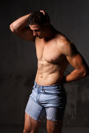 Athlete bodybuilder trains in the studio in the rain.の写真素材