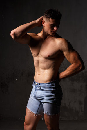 Athlete bodybuilder trains in the studio in the rain.の写真素材