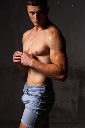 Athlete bodybuilder trains in the studio in the rain.の写真素材