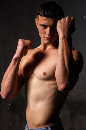 Athlete bodybuilder trains in the studio in the rain.の写真素材