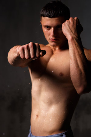 Athlete bodybuilder trains in the studio in the rain.の写真素材