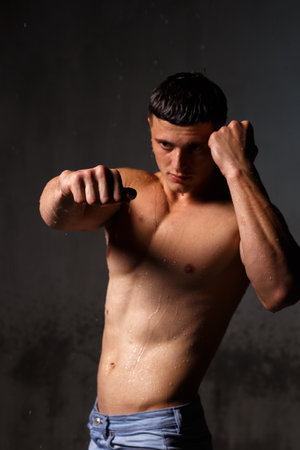 Athlete bodybuilder trains in the studio in the rain.の写真素材
