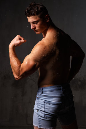 Athlete bodybuilder trains in the studio in the rain.の写真素材