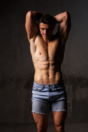 Athlete bodybuilder trains in the studio in the rain.の写真素材