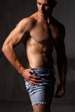 Athlete bodybuilder trains in the studio in the rain.の写真素材