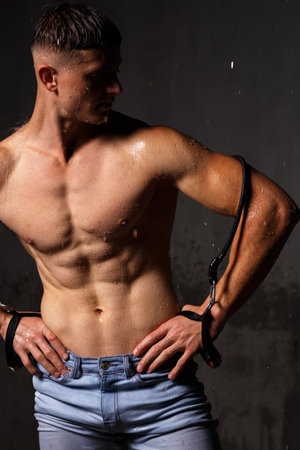 Athlete bodybuilder trains in the studio in the rain.の写真素材