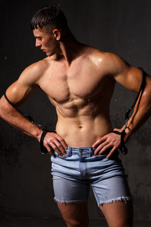 Athlete bodybuilder trains in the studio in the rain.の写真素材
