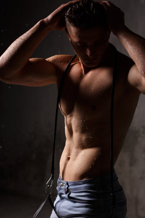 Athlete bodybuilder trains in the studio in the rain.の写真素材