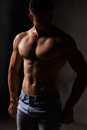 Athlete bodybuilder trains in the studio in the rain.の写真素材
