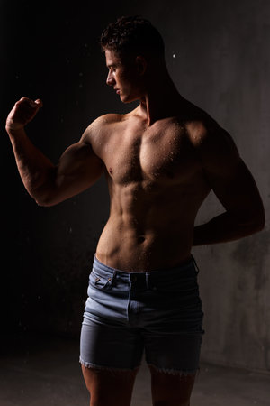 Athlete bodybuilder trains in the studio in the rain.の写真素材