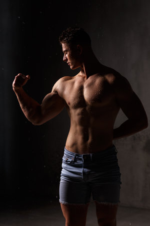 Athlete bodybuilder trains in the studio in the rain.の写真素材