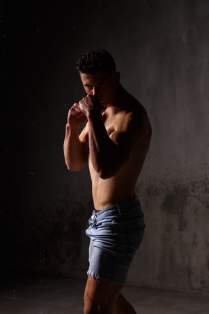 Athlete bodybuilder trains in the studio in the rain.の写真素材