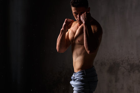 Athlete bodybuilder trains in the studio in the rain.の写真素材