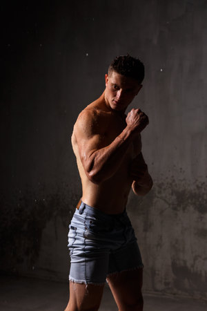 Athlete bodybuilder trains in the studio in the rain.の写真素材