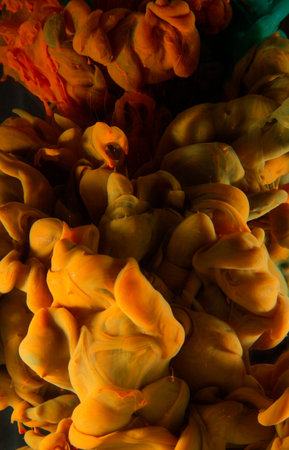 Liquid color drop in dynamic flow creating interesting and unique artistic design. Colorful color tones mixing in water. Isolated on black background.の写真素材