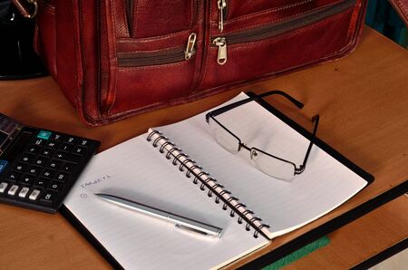 office bag note pad,calculator, specs and penの写真素材