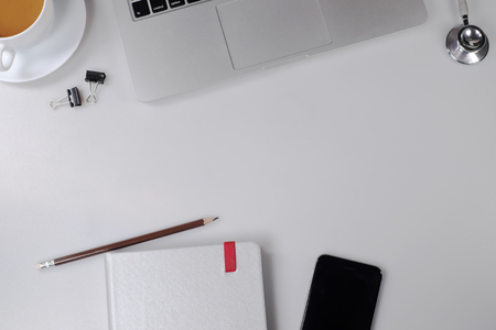 op View of trendy White Office Desk with white Cropped Laptop and green Flowerの写真素材