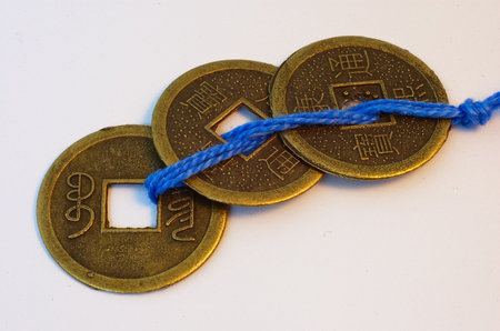 Replicas of three traditional imperial Chinese coins (round with square hole in the center) on a blue string, symbols of wealth and prosperity, Feng Shui toolの写真素材