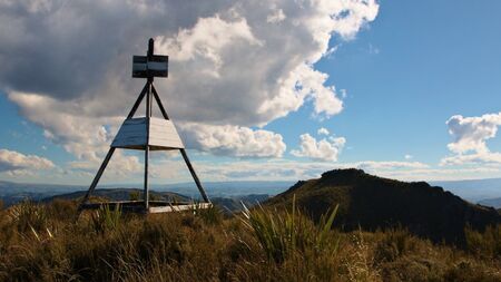 Trig point on top of Silver Peak (also referred to as No 3, 767 metres), looking towards No 2 (777 metres), Silver Peaks, Dunedin, Otago, New Zealandの写真素材
