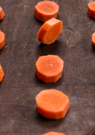On a wooden table in several rows is the carrot slicesの写真素材