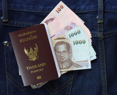 Cash and Thai passport on jeansの写真素材