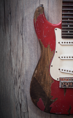 Red old electric guitar on old wood backgroundの写真素材