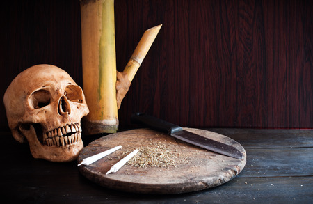 marijuana and bamboo pipe on wood backgroundの写真素材