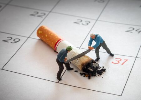 Miniature figure Workers are chopping cigarette with sawの写真素材
