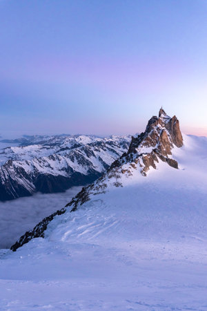 Aiguille du Midi and Cosmiques Ridge during purple sunrise in Chamonix Mont Blanc, France.の写真素材