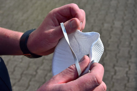 Hands holding a respiratory mask of the category FFP2.