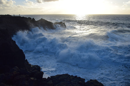 Los Hervideros at the west coast of Lanzarote in the evening sun. Ocean waves breaking at the lava...