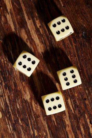 Four dice showing sixes on table, overhead viewの写真素材