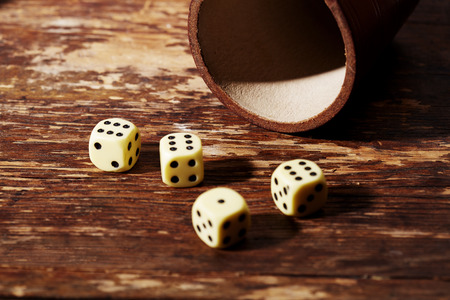 Four dice showing sixes on tableの写真素材