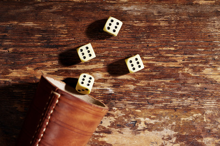 Four dice showing sixes on table, overhead viewの写真素材