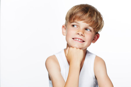 Young boy in vest looking away, studioの写真素材