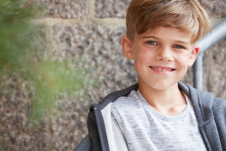 Portrait of young boy smiling at camera, outdoors