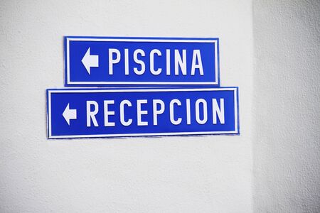 Blue Spanish resort signs on white wallの写真素材