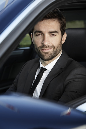 Smiling businessman driving carの写真素材