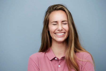 Eyes closed and smiling beautiful woman, studioの写真素材