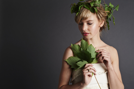 Beautiful woman wearing green garland, studioの写真素材