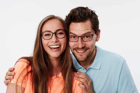 Happy couple in glasses smiling at cameraの写真素材