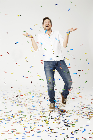 Man showered with confetti, studio shotの写真素材