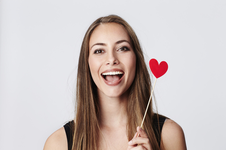 Beautiful woman with heart shape, laughingの写真素材
