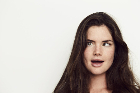 Girl with crossed eyes in white studioの写真素材