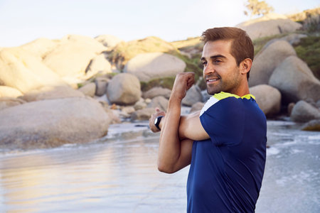 Smiling athlete on beach, looking away