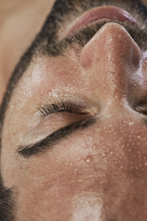 Close up of man's face beaded with sweatの写真素材