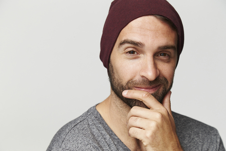 Smiling stubble guy with red hat, portraitの写真素材