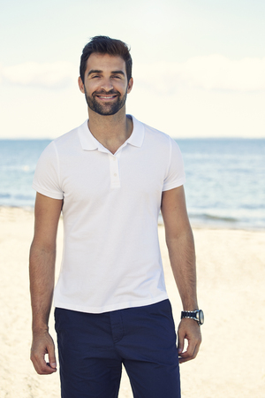 Portrait of man smiling on beachの写真素材