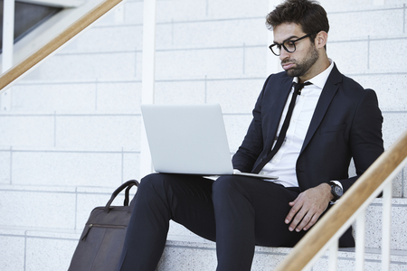 Bored businessman sitting on stairsの写真素材