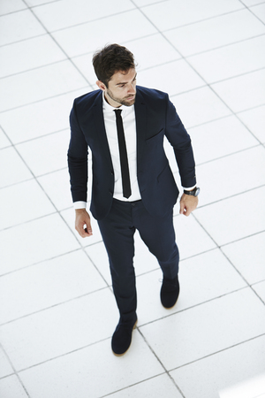 Business dude walking on white tilesの写真素材